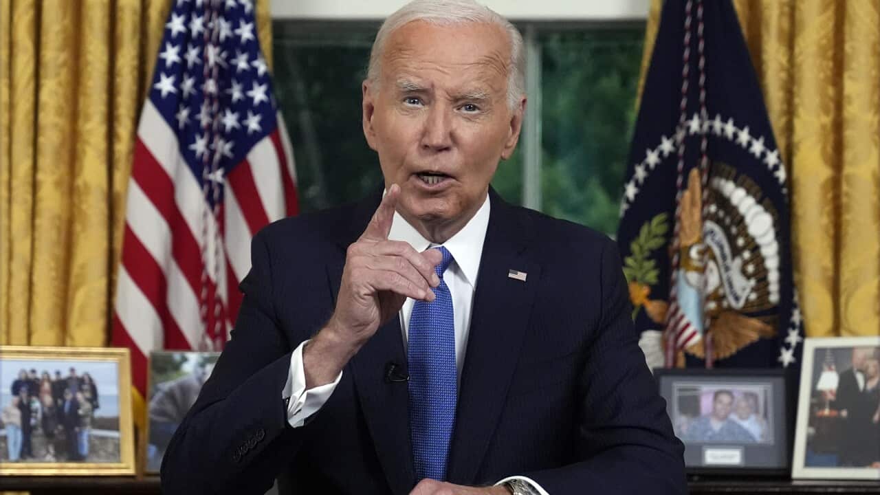 Joe Biden to a camera while seated at a desk.