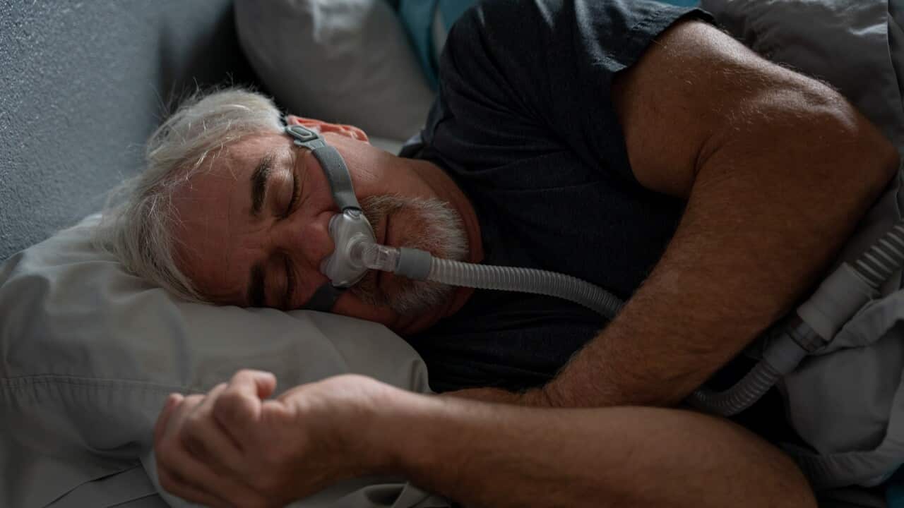 Mature Man With Sleep Apnea Wearing A CPAP Mask In Bed Sleeping