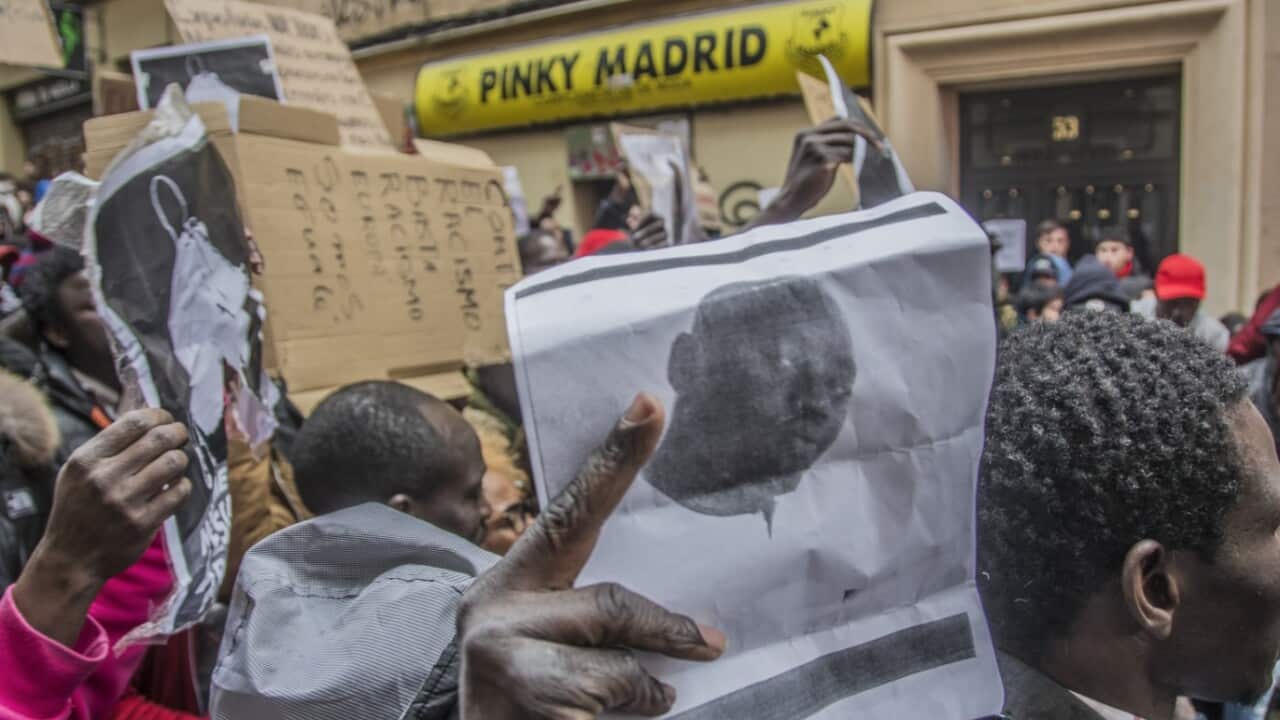 Demonstrators hold signs during a protest on March 16, 2018 in support of Senegalese vendor Mmame Mbage who died in Madrid. 