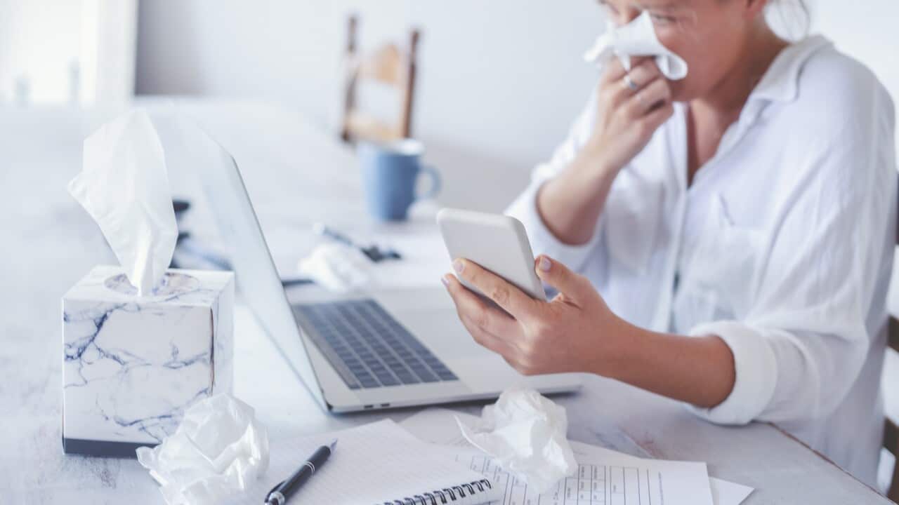 Woman with a cold or flu or allergy working at home