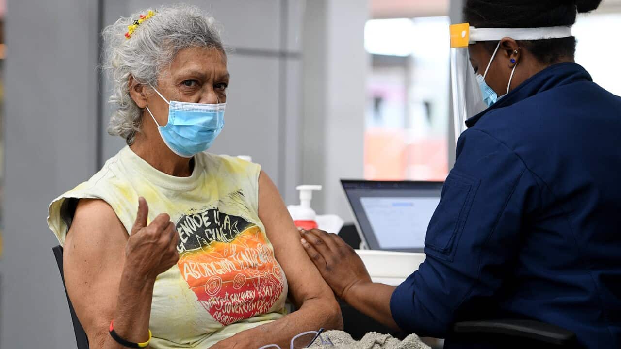 Australian Wiradjuri elder and Indigenous rights activist Aunty Jenny Munro gestures after receiving a Covid-19 vaccine at a pop-up vaccination clinic
