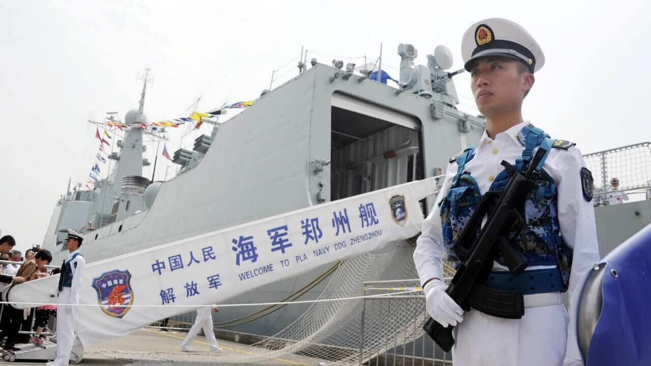 Armed Chinese navy soldiers stand guard in front of Chinese missile destroyer Zhengzhou.