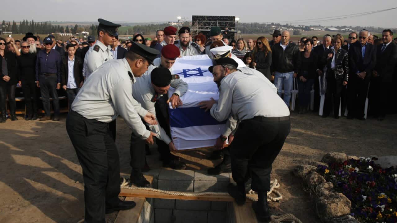 Israeli army officers lower the coffin of Ariel Sharon
