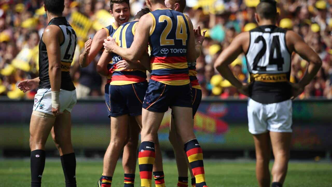 Mitch McGovern of the Crows is congratulated by team mates