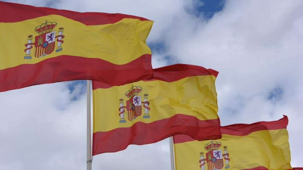 Spanish national flags are seen flapping in the wind