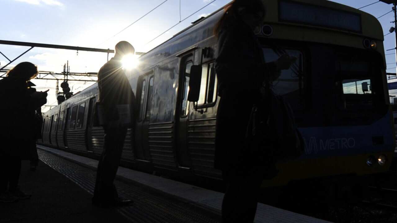 A Metro train approaches a Melbourne train station