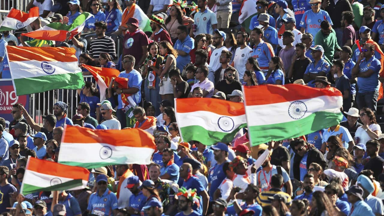 Indian cricket fans wave their national flags during the Cricket World Cup match between West Indies' and India at Old Trafford in Manchester.