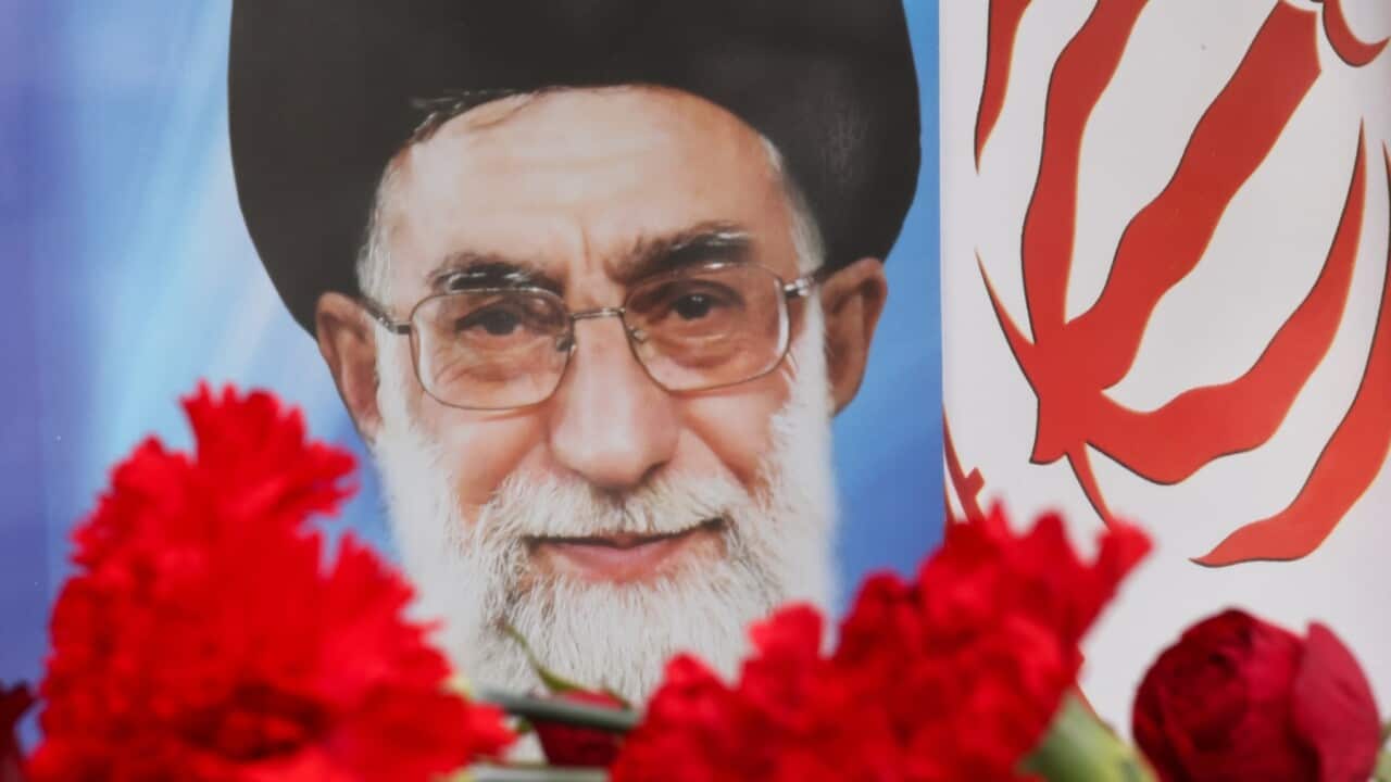 A photo Iran's Supreme Leader Ayatollah Ali Khamenei with flowers and the Iranian flag
