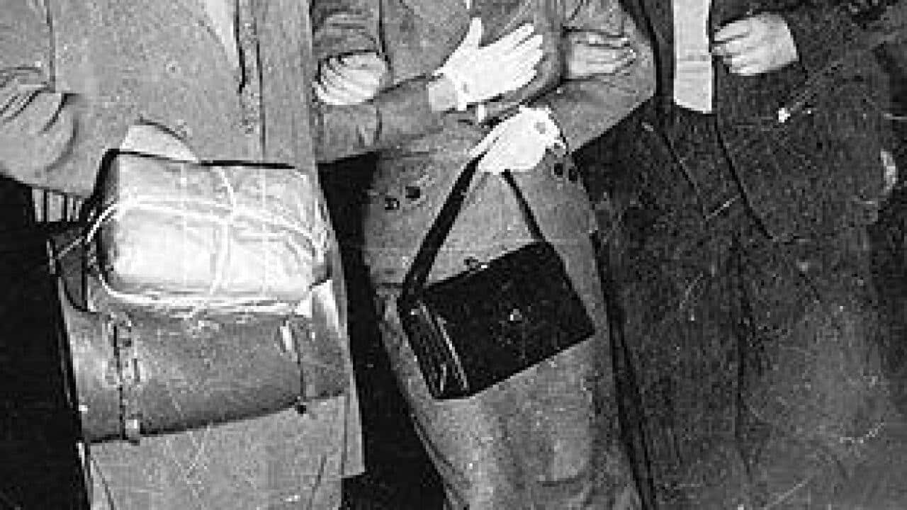 19 April 1954, former Soviet spy Evdokia Petrov, escorted by armed Russian couriers to a waiting plane at Darwin Airport aap.jpg