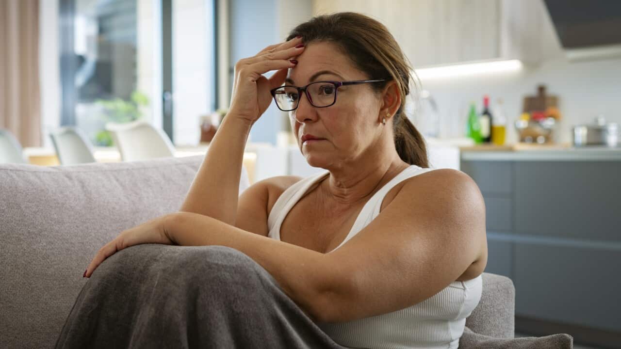 A woman looking pensive holding her head