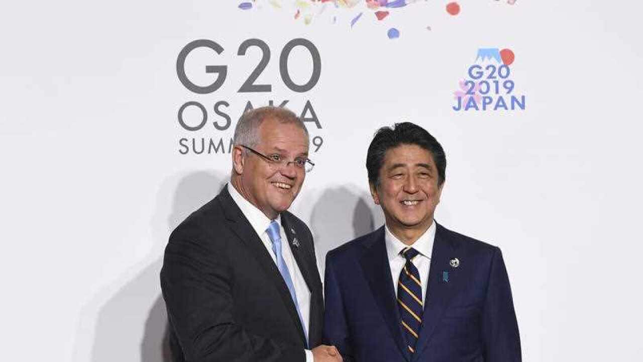 Prime Minister Scott Morrison shakes hands with Prime Minister of Japan Shinzo Abe during the Leaders Welcome at the G20 summit in Osaka, Japan