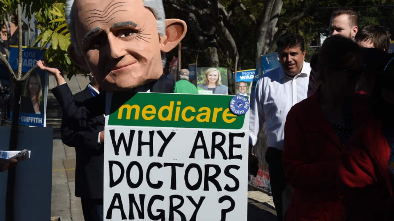 A protester wearing a giant puppet head depicting Malcolm Turnbull