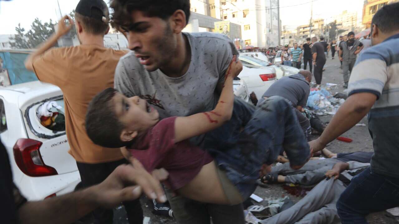 An injured Palestinian boy is carried from the ground following an Israeli airstrike outside the entrance of the al-Shifa hospital in Gaza City, Friday, Nov. 3, 2023.