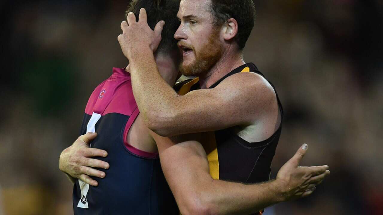 Melbourne's Jesse Hogan (L) embraces Hawthorn's Jarryd Roughead