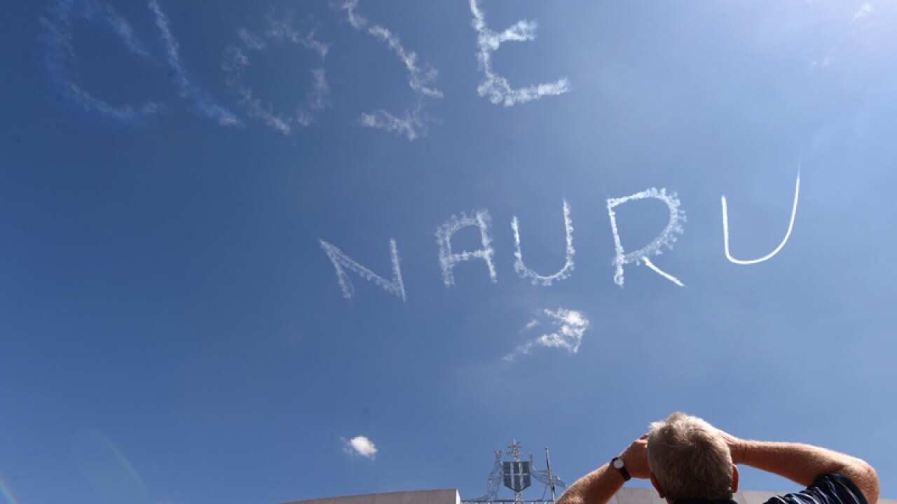 A plane skywrites "CLOSE NAURU" above Parliament House