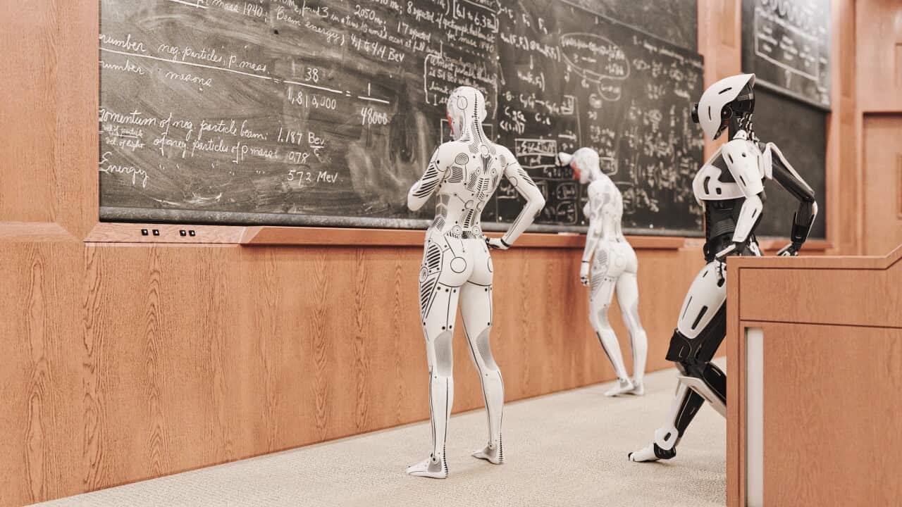 Robots standing at a blackboard.