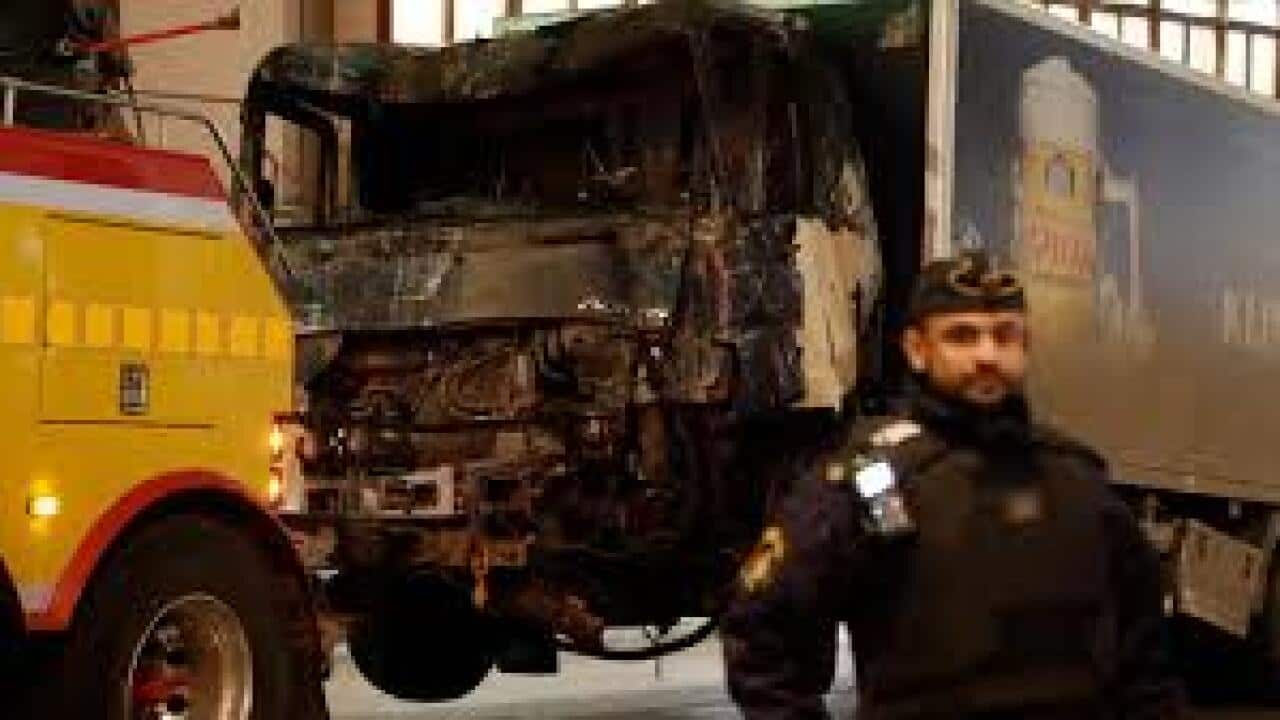 A destroyed truck is pulled away by a service car after it was driven into a department store in Stockholm, Sweden