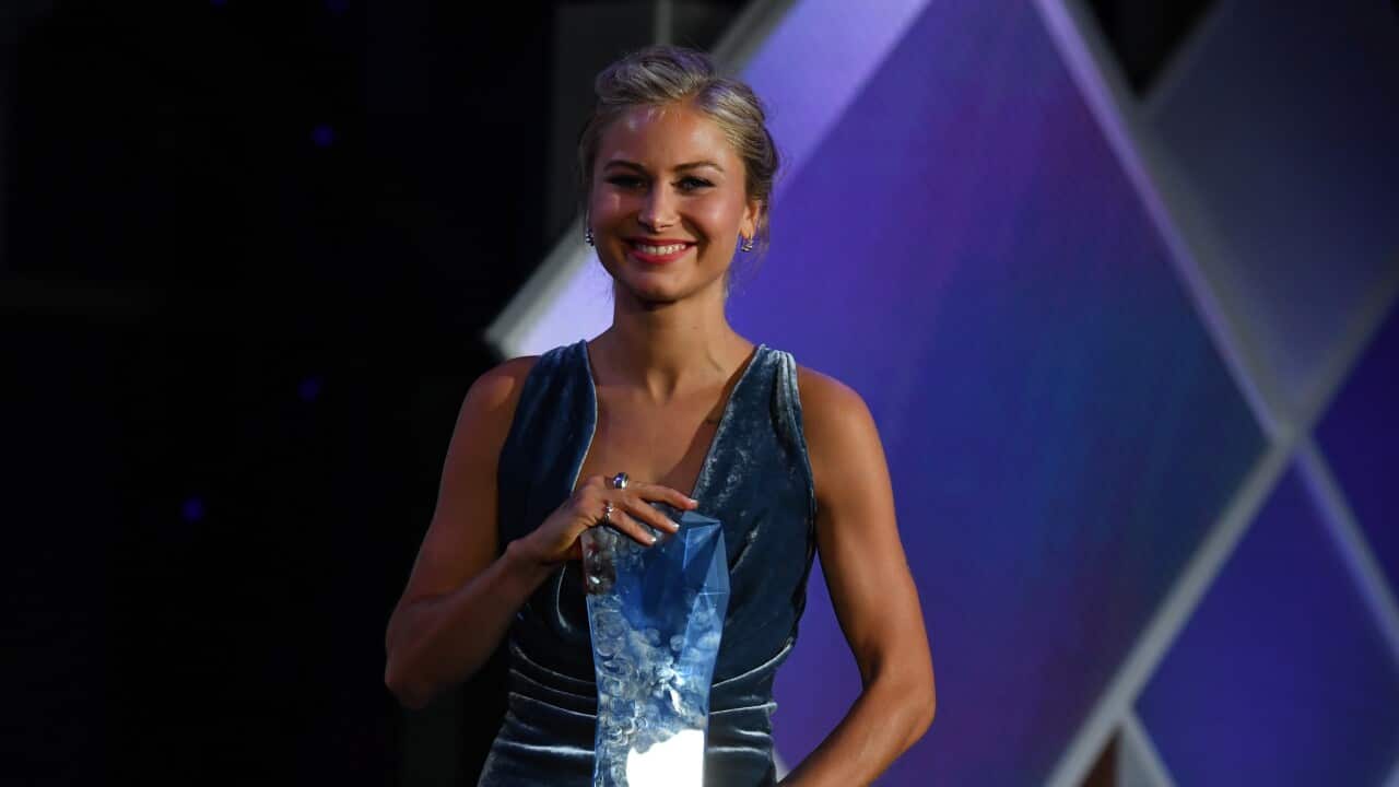 A woman holding an award
