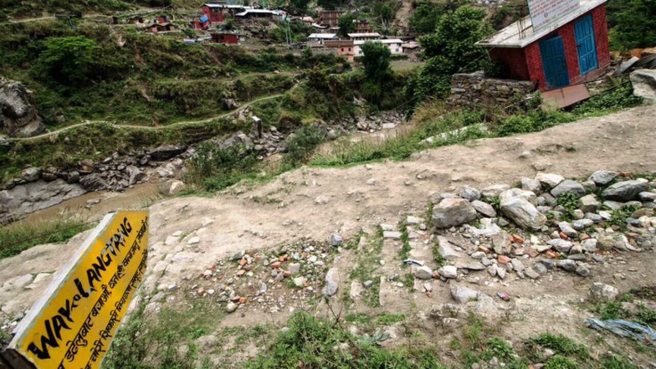 A sign shows the start of the Langtang Trail, Nepal, the day after a massive earthquake hit the region.