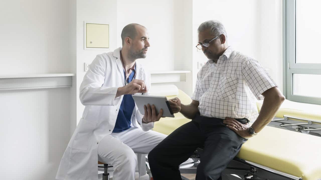 Doctor and senior patient discussing medical test results using digital tablet