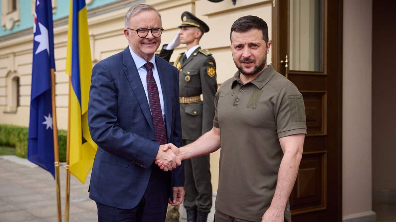 Prime Minister Anthony Albanese and Ukraine President Volodymyr Zelenskyy standing outside a building in Ukraine and shaking hands