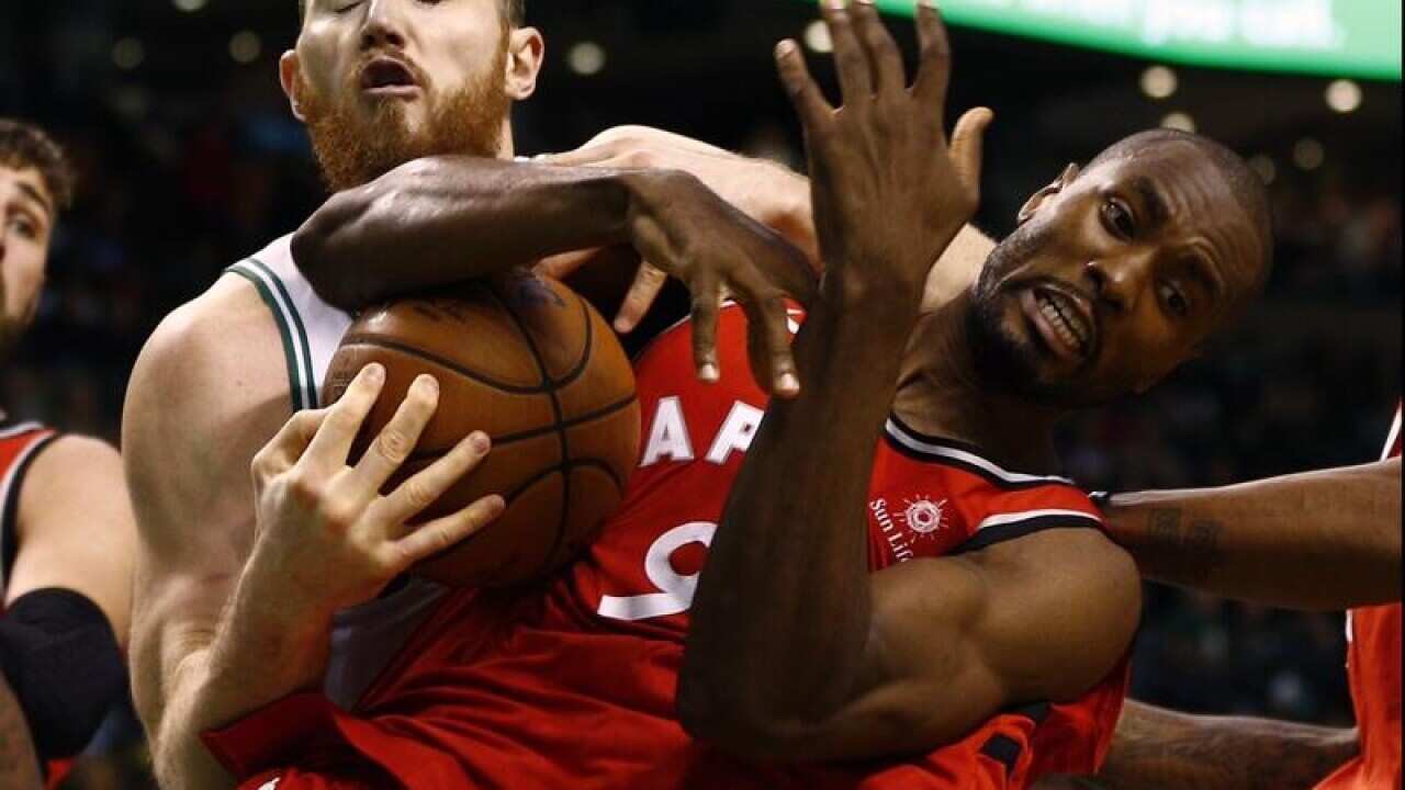 Celtic's Aron Baynes (L) Raptor's Serge Ibaka (R) battle for the ball.