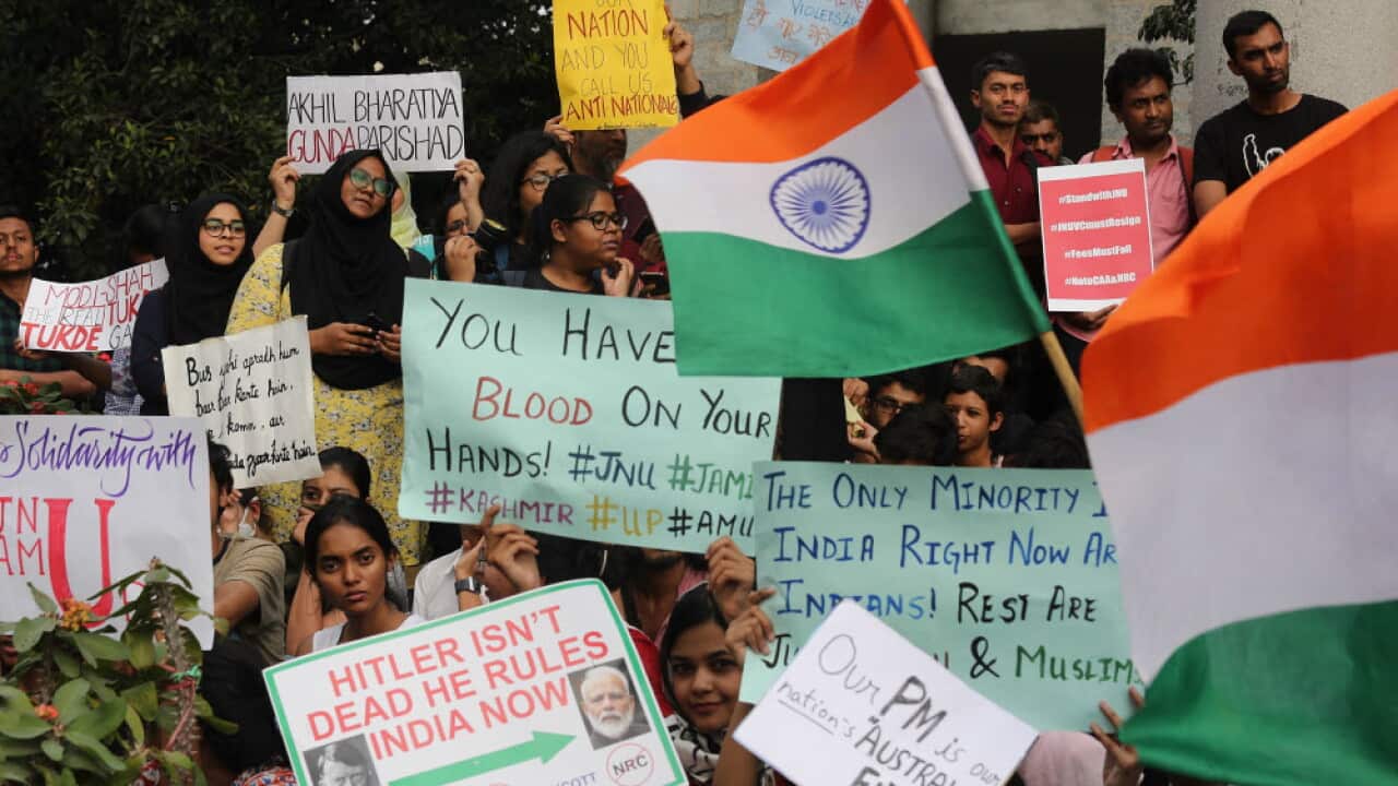 Young protesters holding signs during a political demonstration in India.