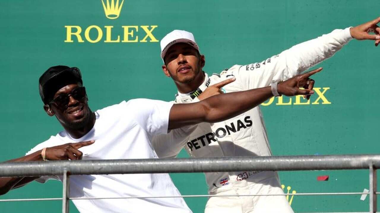 Lewis Hamilton (R) celebrates his F1 win with Usain Bolt