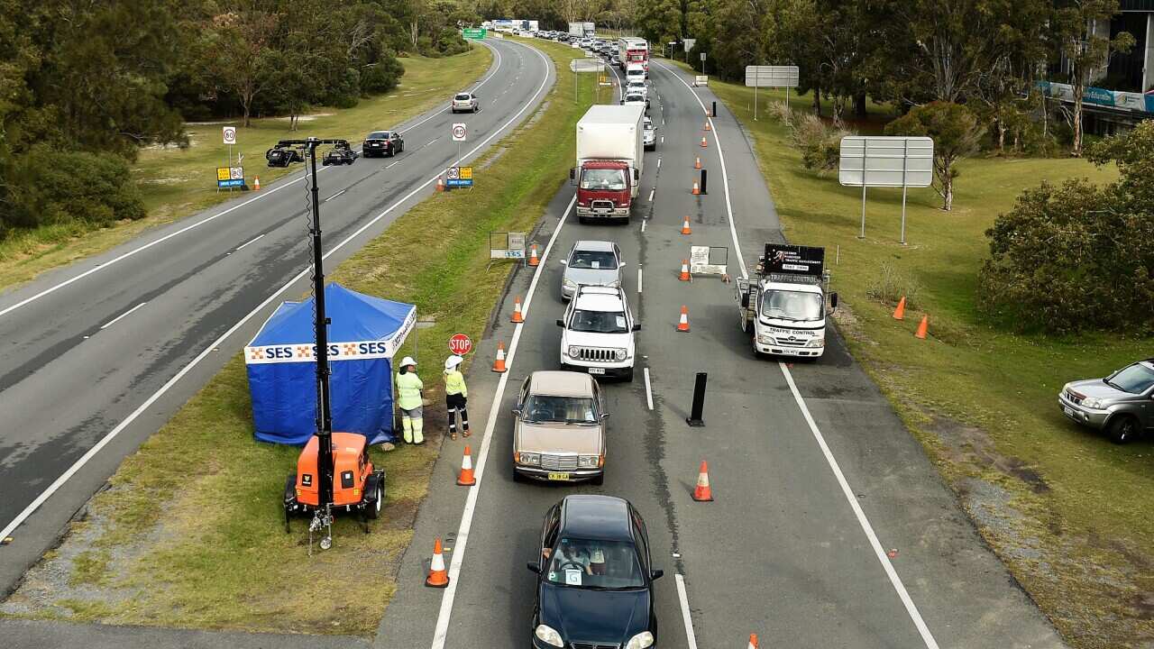 Cars wait to cross the border at Gold Coast Highway checkpoint on the Gold Coast.