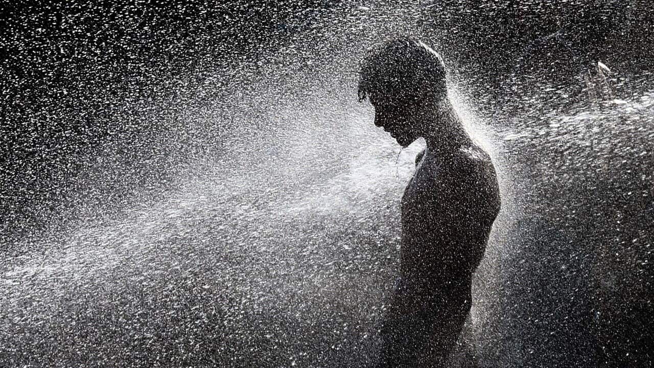 epaselect epa08523016 People cool off at a punctured water supply line on a road as a heatwave continues in Karachi, Pakistan, 02 July 2020. EPA/SHAHZAIB AKBER