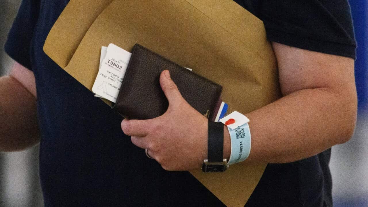 A newly arrived passenger to Hong Kong wears a blue quarantine tracking wrist band