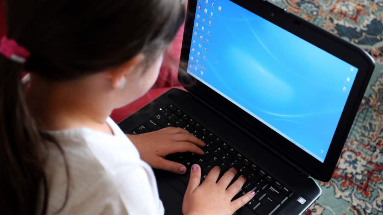 A school child using a laptop computer