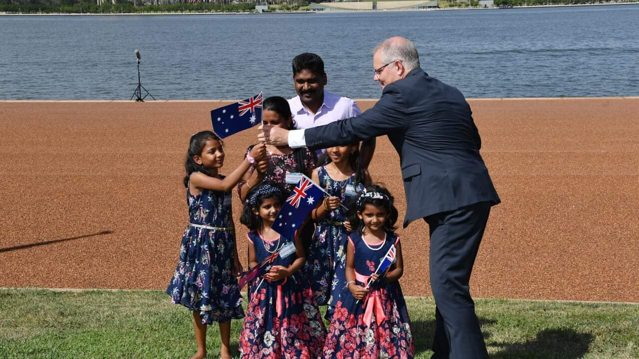 Prime Minister Scott Morrison hands out Australian flags at an Australia Day Citizenship Ceremony, 2019.