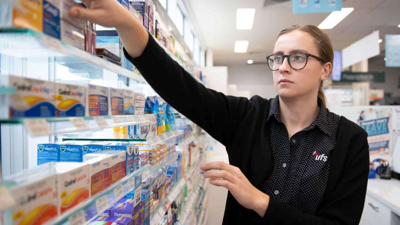 A pharmacist reaches for medicine at a shop in Coburg, Melbourne