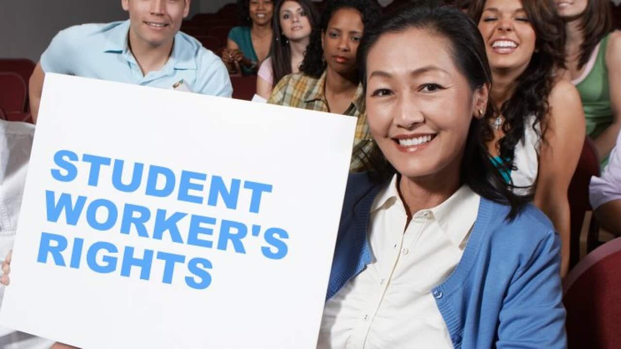 Female teacher holding blank board in front of class portrait