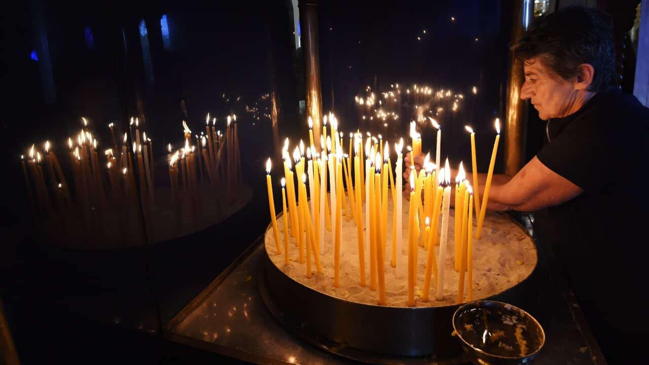 A parishioner lights a candle during a Good Friday service at Greek Orthodox Church in Sydney.