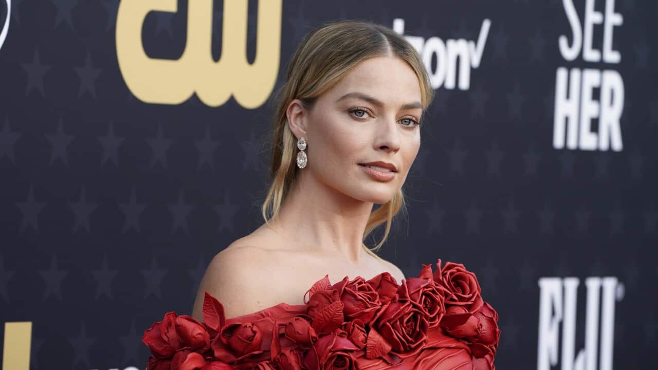 Margot Robbie wearing a red dress at an awards ceremony