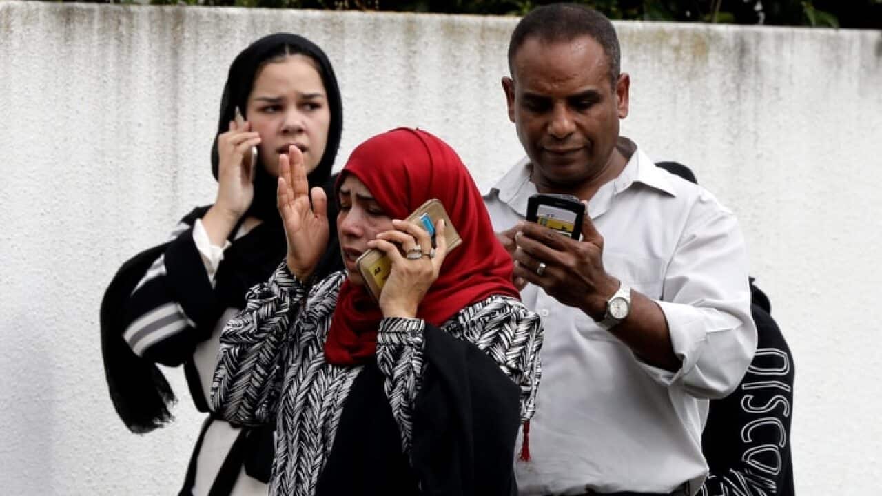 People wait outside a mosque in central Christchurch, New Zealand