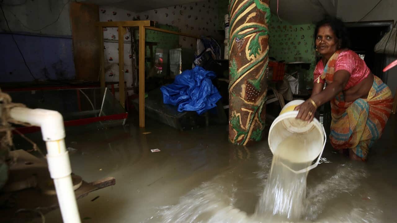 A woman uses a bucket to remove water from inside her flooded house in the Hormavu area following heavy rainfall in Bangalore, India.