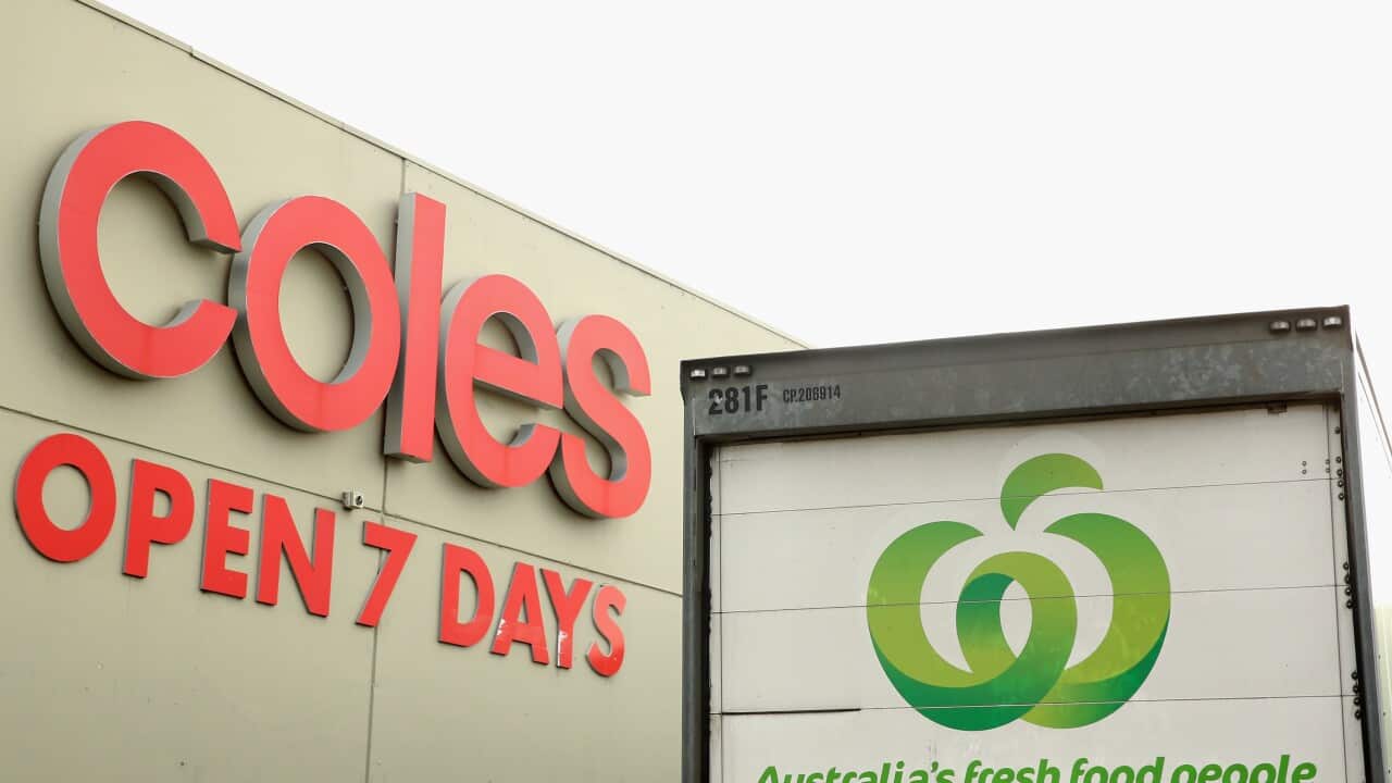 A Woolworths van parked outside of a Coles building.