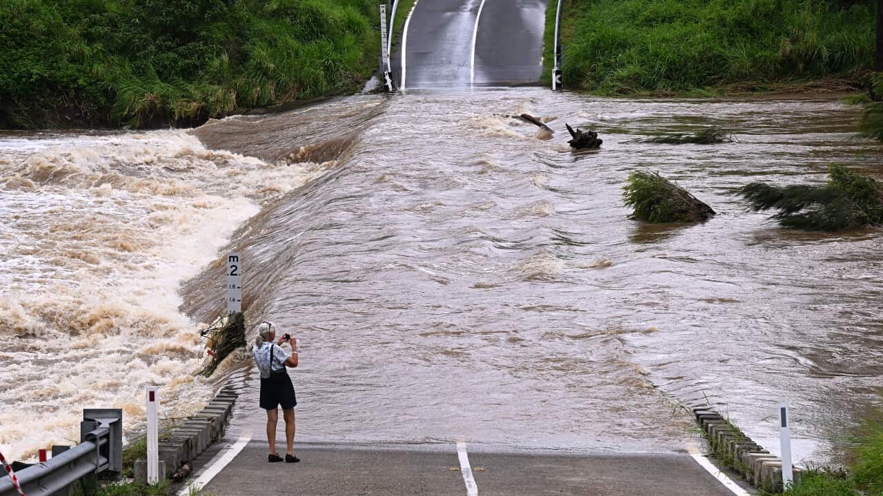 A person standing next to floodwaters