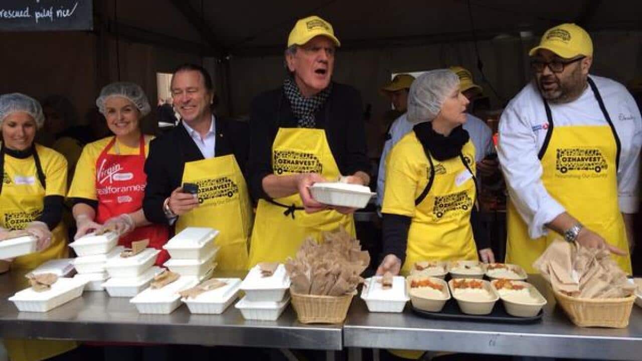 Volunteers serve food in Sydney's Martin Place during OzHarvest's Think.Eat.Save program. (Emma Hannigan, SBS)