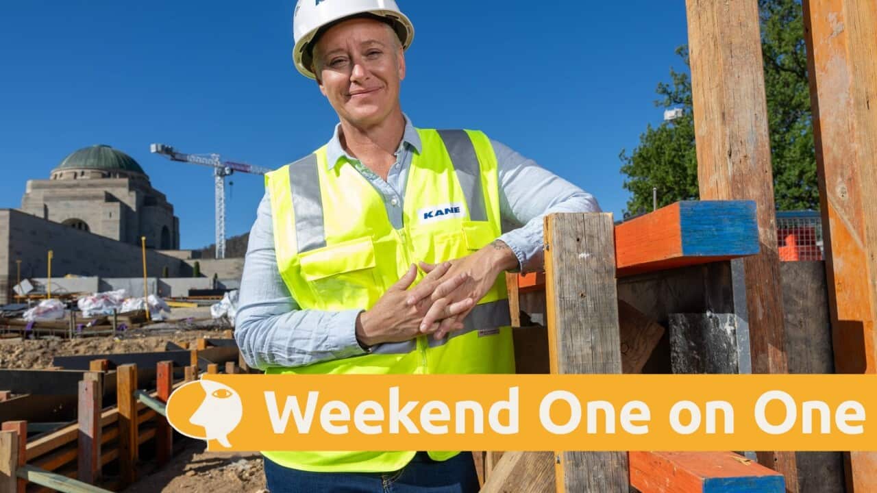 Jo smiles as she stands on a construction site.