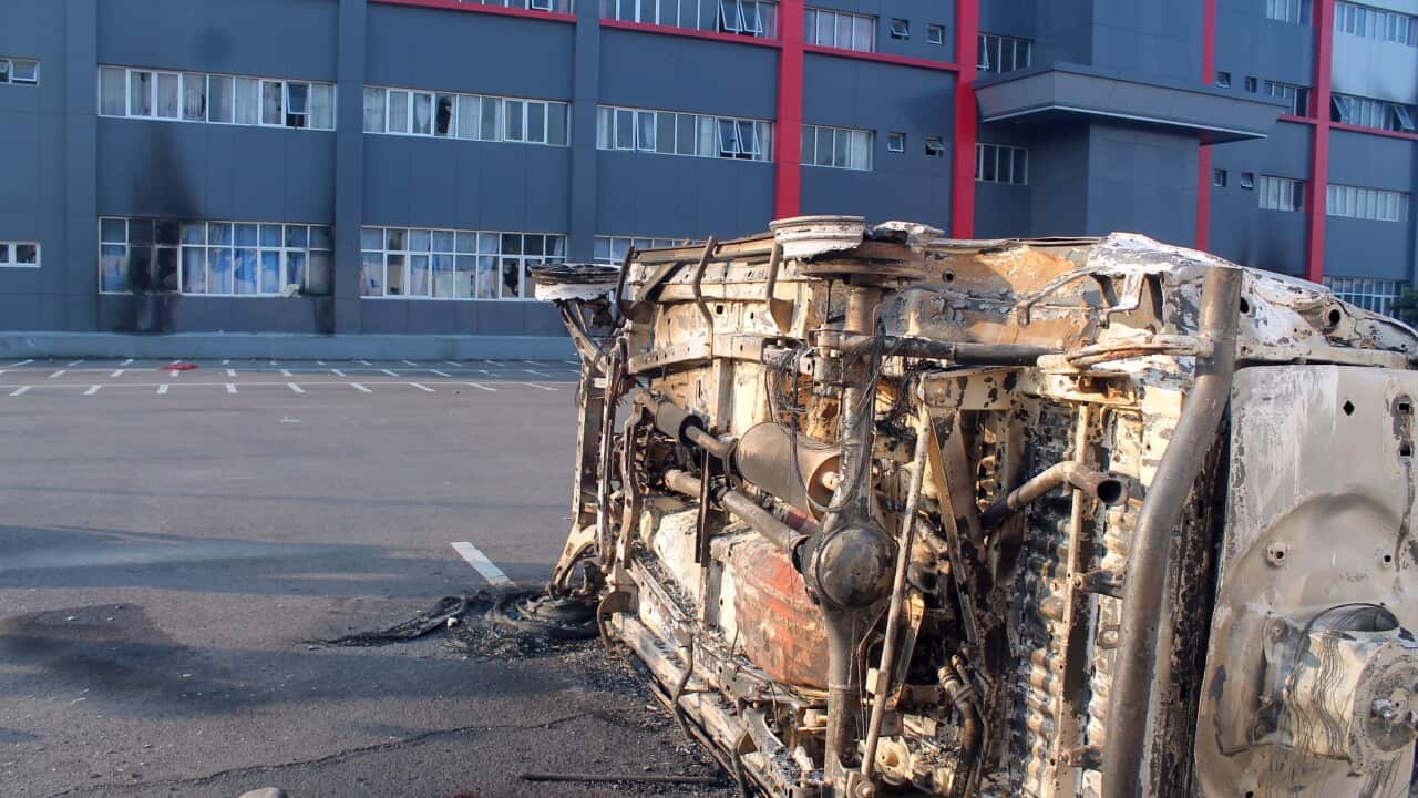 A burnt car that was allegedly torched by protesters, sits on the road during a violent rally in Wamena, Papua Province, Indonesia.