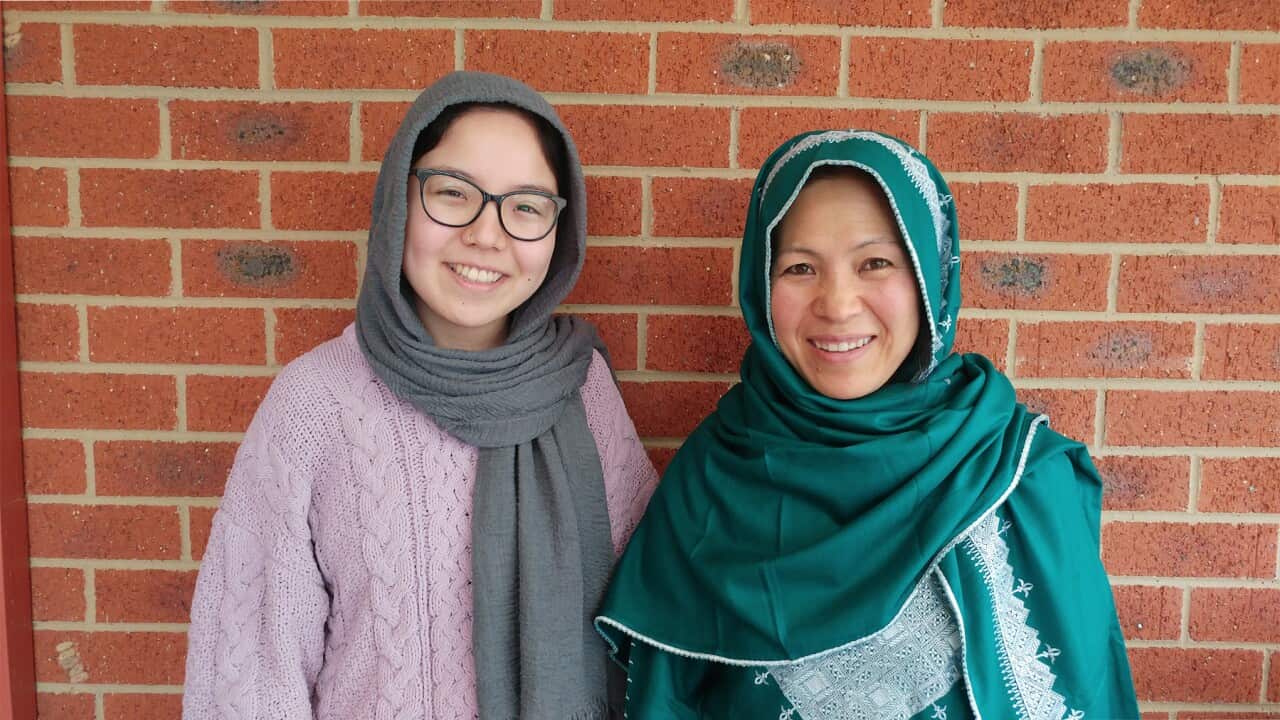photograph of Hussnia and daughter Mahssama in front of brick wall.