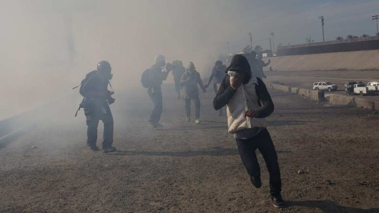 US agents launched gas canisters at migrants attempting to breach the border fence with Mexico.