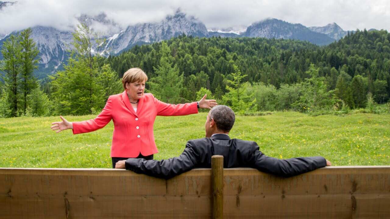 Angela Merkel talks with Barack Obama.
