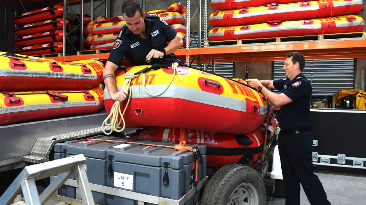 Emergency services prepare a rescue boat for the water.