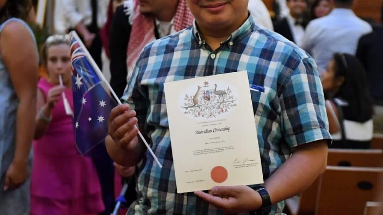 An Australian citizenship recipient poses for a photo after  a citizenship ceremony on Australia Day in Brisbane, Thursday, Jan. 26, 2017. (AAP Image/Dan Peled) NO ARCHIVING