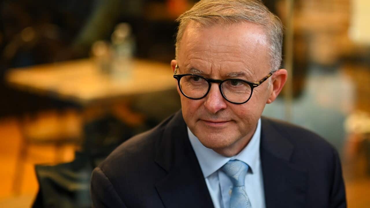 Australia Opposition Leader Anthony Albanese drinks a coffee during a meeting with locals at a cafe in the Top Ryde City mall on Day 11 of the 2022 federal election campaign, in Sydney, Thursday, April 21, 2022. (AAP Image/Lukas Coch) NO ARCHIVING